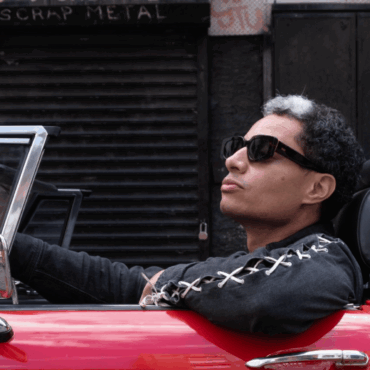 José James in auto su una decappottabile rossa